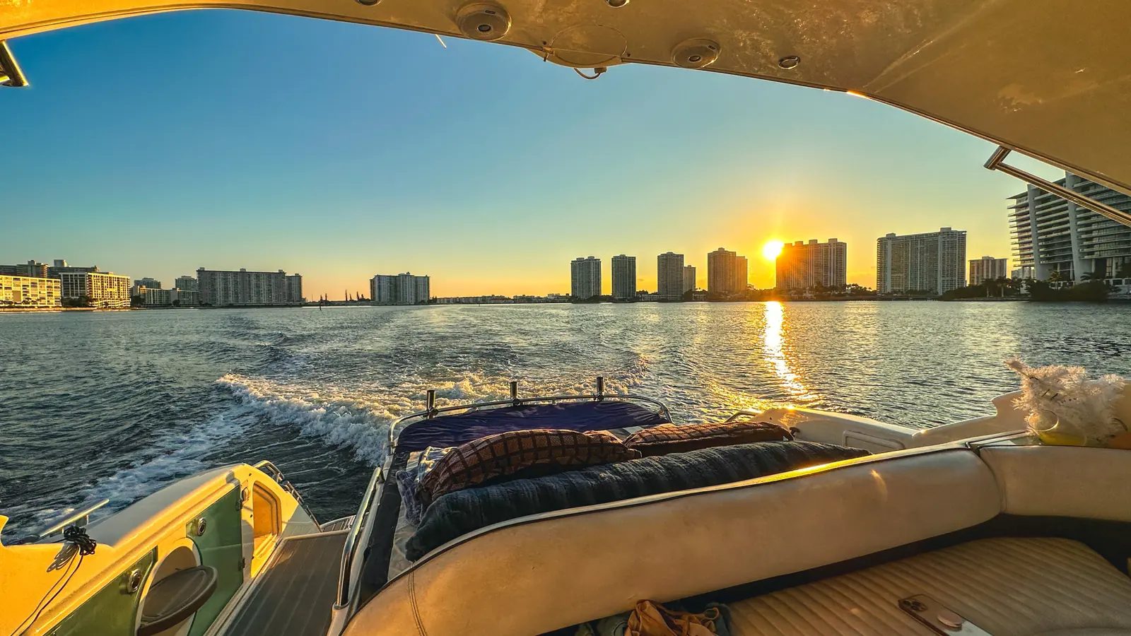 Boat wake leading toward the Fort Lauderdale skyline at sunset